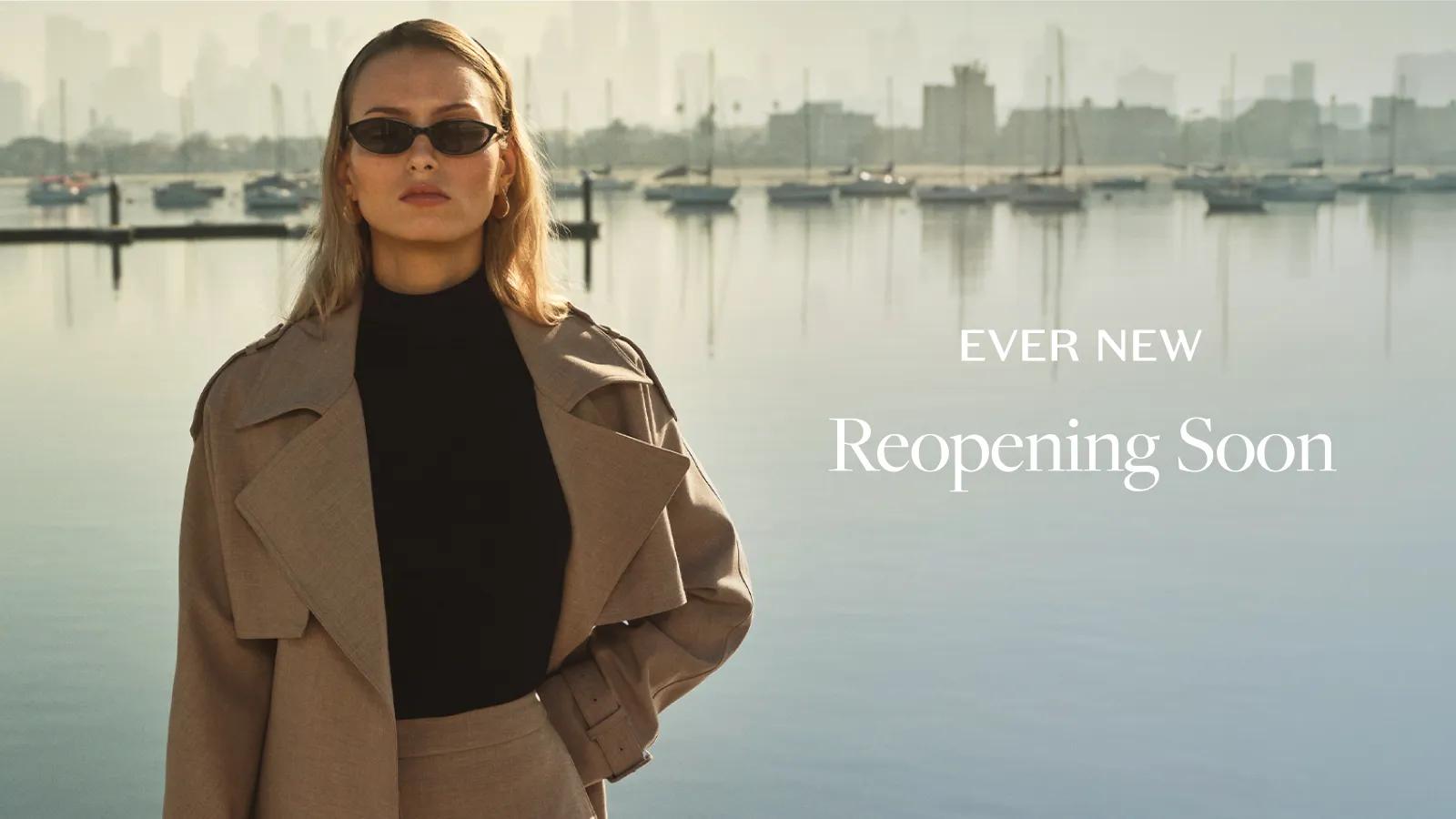 An Ever New "Reopening Soon" banner featuring a model in a trench coat by a harbor.
