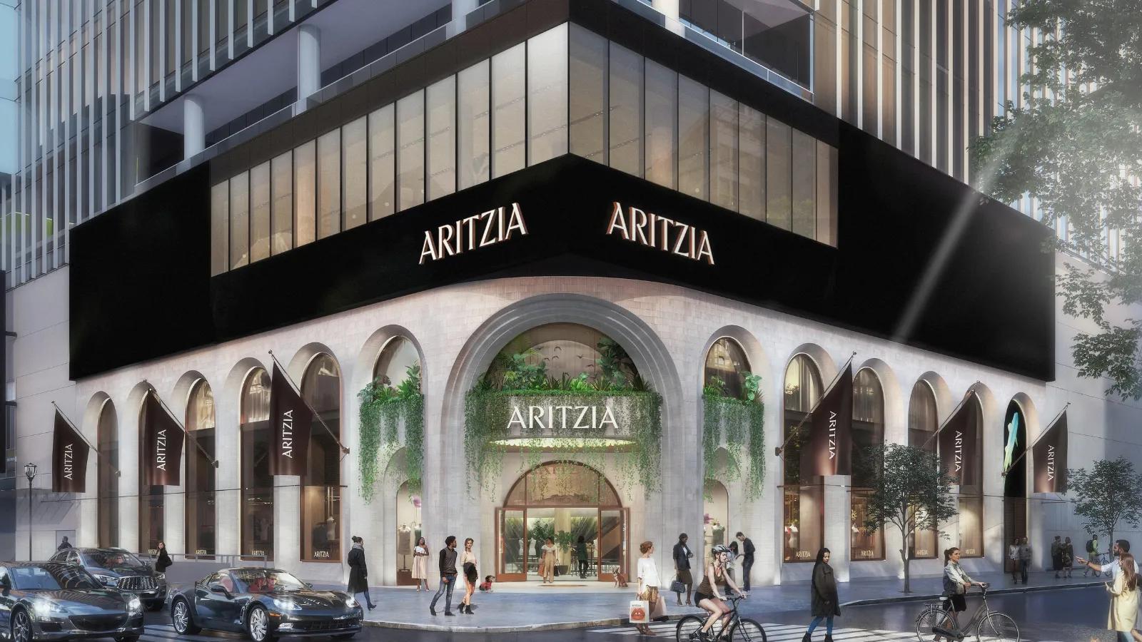 An architectural rendering of a multi-story Aritzia store exterior featuring grand stone arches and large glass windows.