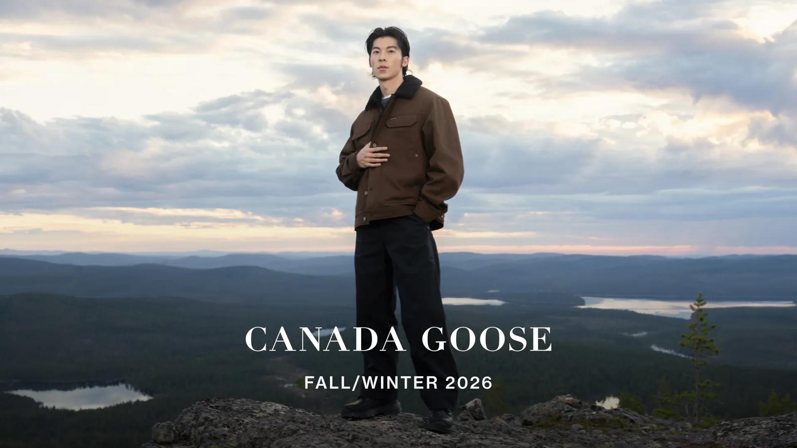 Actor Greg Hsu posing on a mountain peak in a brown jacket for a Canada Goose Fall/Winter campaign.